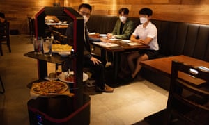 Coronavirus live news: nearly a fifth of South Africans may have had Covid; record new cases in the Netherlands - KT’s AI trolley-like robot carries food to customers during a demonstration at Mad for Garlic restaurant in Seoul, South Korea, on Tuesday.