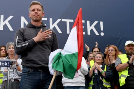 Péter Magyar holding a Hungarian flag with his right hand on his heart