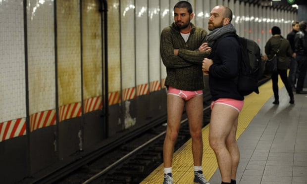 Men without trousers stand at a platform.