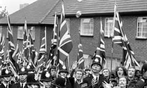 A police sergeant prepares to catch a can thrown at the National Front marchers