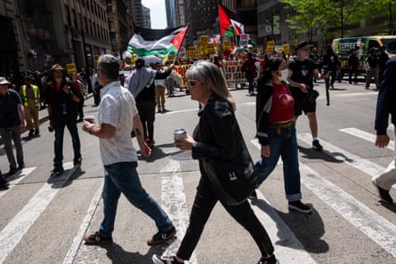 people holding signs and flags cross street