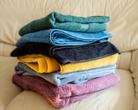 colorful bath towels folded and stacked on a sofa