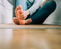 Woman massages her feet on yoga mat