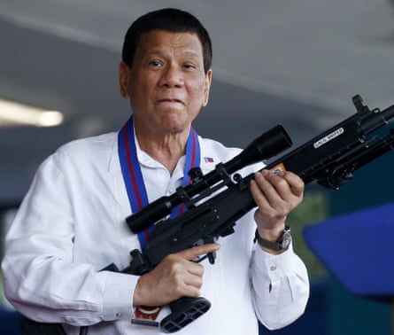 Rodrigo Duterte holding a rifle in 2018.