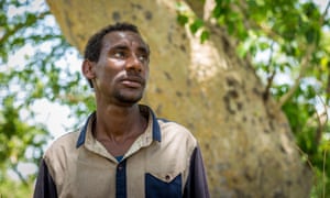 Getachew Merah, a 30-year-old migrant from Ethiopia, stands by a tree near Metema, on 4 June 2015. 