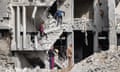 People inspect the wreckage of a partially collapsed building due to Israeli bombardment in Gaza on 18 April 2024