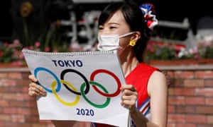Seorang pemandu sorak di stasiun Shimbashi di Tokyo pada Kamis pagi.