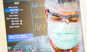 A doctor looks at a patient’s readings on a health monitor.