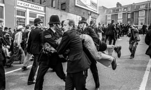 A protester is hauled away