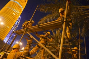 Labourers from Nepal put up scaffolding for the launch of the World Cup logo. They start work long before sunrise to avoid the heat.