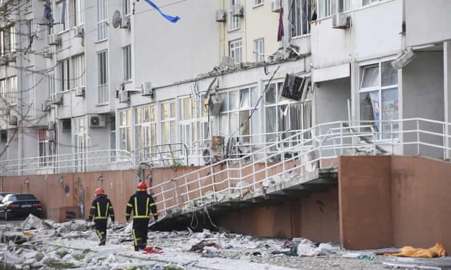 Firefighters walk past an apartment building damaged by Russian shelling in Odessa, Ukraine.
