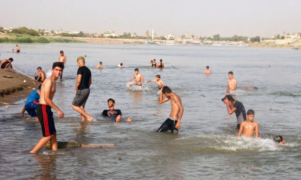Iraqis swim to cool themselves in the Tigris river in Baghdad, Iraq, where temperatures are expected to reach 49C this week