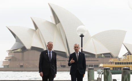 Canada's defence minister David McGuinty, left, talks with Canada's prime minister Mark Carney as they walk to a news conference, in Sydney, Australia, Wednesday, 4 March 2026.