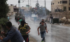 Palestinian protesters run from teargas fired by Israeli soldiers during clashes in the West Bank.