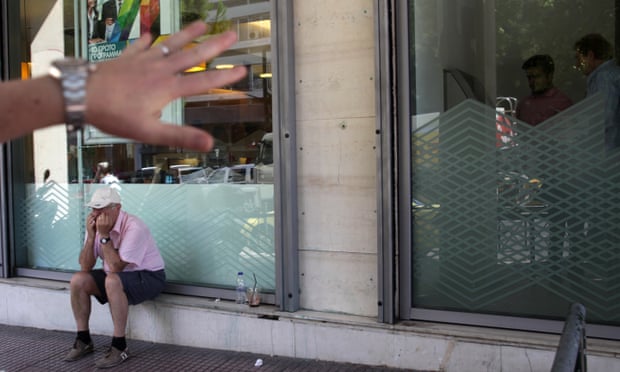 A pensioner sits outside a bank in Athens.