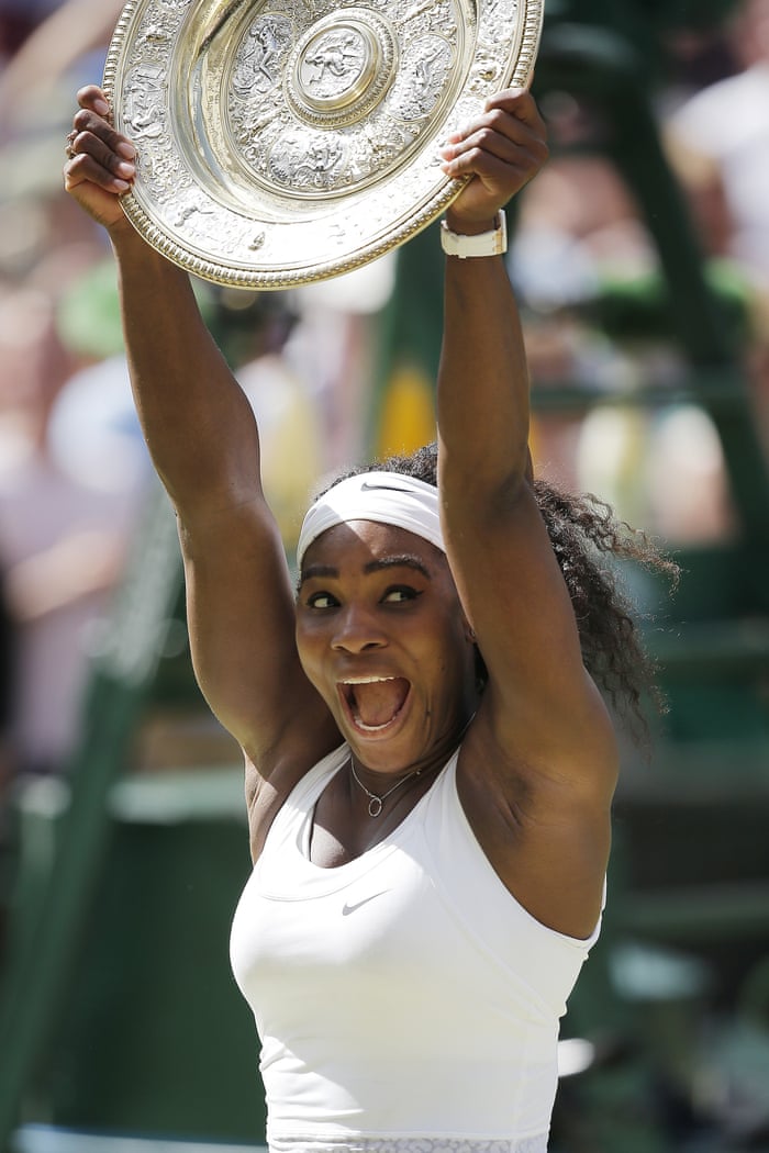 An elated Serena Williams holds the winners trophy aloft