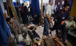 People wounded in Syria market attack receive treatment at a makeshift hospital in Douma.