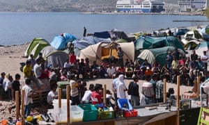 Migrants gather for a meeting at an unofficial camp run by volunteers near the port of Mytilene on the island of Lesbos