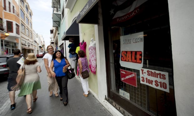 People walk past a closed store in San Juan, Puerto Rico.