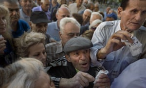 Pensioners holding their queue numbers try to enter a bank in Athens.