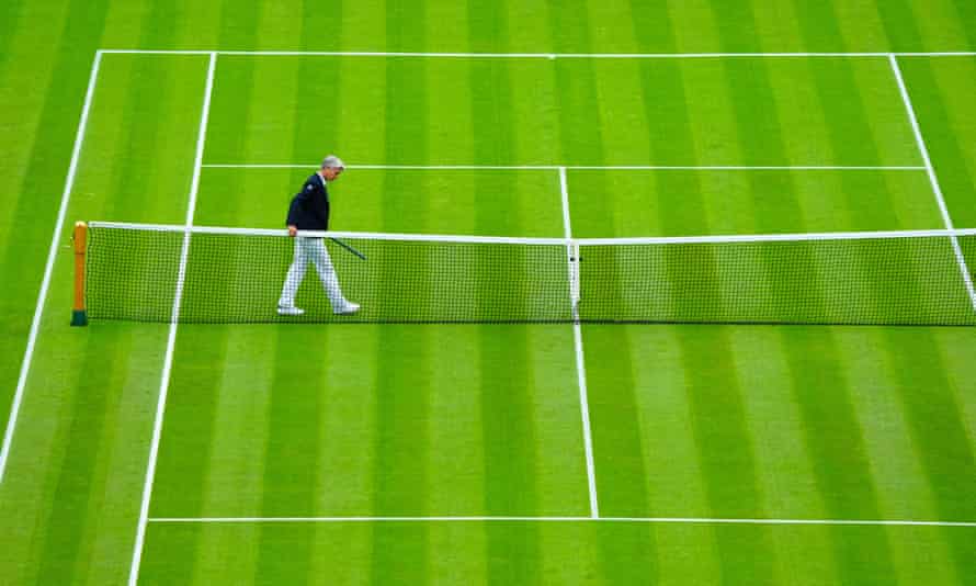 The shorter net on Centre Court is inspected.