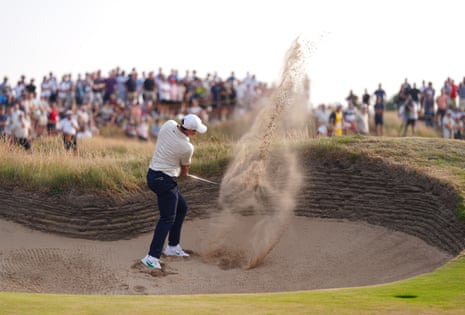 Rory McIlroy chips out of the bunker on the 14th.