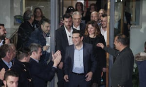 Alexis Tsipras, leader of Greece’s Syriza left-wing party, followed by his partner Peristera (Betty) Baziana, greets his supporters outside Syriza’s headquarters in Athens, Sunday, Jan. 25, 2015.