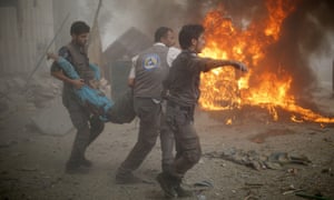 Emergency personnel carry a wounded man after air strikes by Syrian government forces on a marketplace in the rebel-held area of Douma on Sunday 16 August