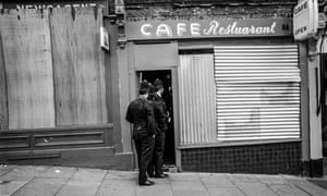 Police move into a boarded-up cafe to check for demonstrators who had been throwing missiles from upper floors