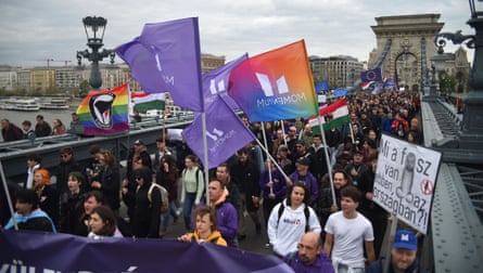 A group of protesters with flags on a bridge