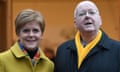Head and shoulders shot of Peter Murrell and Nicola Sturgeon posing for press photographers