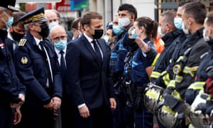 Emmanuel Macron (4th-L) talks to emergency workers at the scene of the attack.