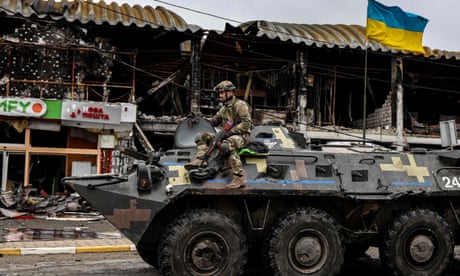 An Ukrainian soldier patrols in an armoured vehicle a street in Bucha, north-west of Kyiv