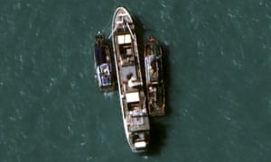A 14 July 2015 satellite image provided by DigitalGlobe shows two fishing trawlers load slave-caught fish onto the Silver Sea 2, centre
