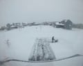 A view of buildings and a street covered in snow.