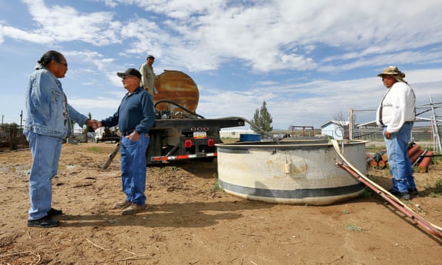 Members of the Shiprock chapter of the Navajo Nation pump fresh water into a basin in Shiprock, New Mexico, on Wednesday