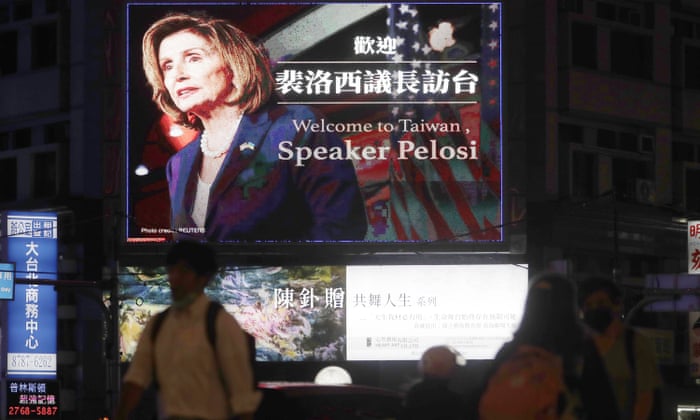 People walk past a billboard welcoming U.S. House Speaker Nancy Pelosi, in Taipei, Taiwan, Tuesday, Aug 2, 2022.