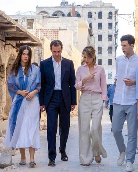 Bashar al-Assad and his family walk alongside the rubble in Aleppo.