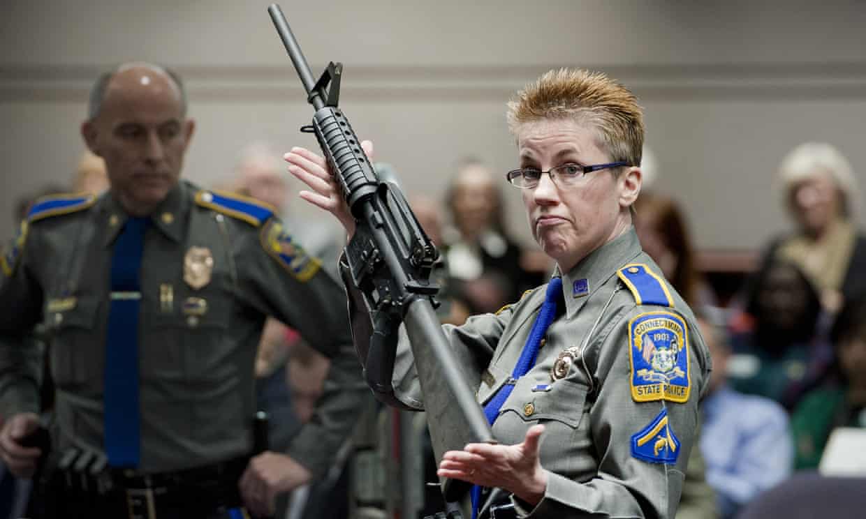 A Connecticut state police officer holds up an AR-15 rifle during a state legislative hearing on gun laws. Photograph: Jessica Hill/AP