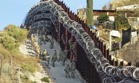'It's not the same': How Trump and Covid devastated an Arizona border town - US army troops place additional concertina wire to the border fence on a hillside above Nelson Street in downtown Nogales in 2019.
