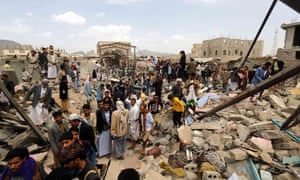人々は7月20日、サヌア、イエメン、サウジアラビア主導の連合によって行わ空爆で破壊され、市場に集まります。