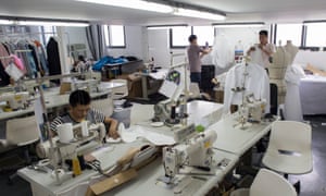 A man at a sewing machine and others working in Masha Ma’s Shanghai studio.