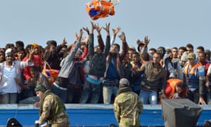 Royal Marines with migrants rescued off the Libyan coast in June.