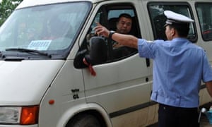 A police officer directs traffic on a road leading to the rescue site of the overturned passenger ship in the Jianli section of the Yangtze River.