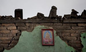A portrait of Hindu goddess Lakshmi hangs on the remains of a house in Kathmandu