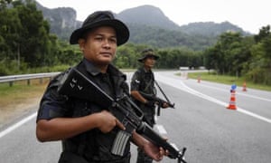 Malaysian police stand guard at the Malaysia-Thailand border in Wang Kelian. 