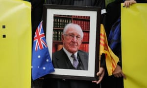 Members of the Vietnamese community holds signs and a photograph aloft outside of Scots Church during the State Funeral for the Right Honourable Malcolm Fraser on March 27, 2015 in Melbourne.