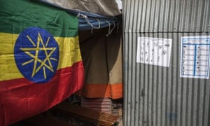 An Ethiopian flag hangs next to instructions on the voting process and a poster with the competing parties at a polling station in the Cazanchise area of Addis Ababa.