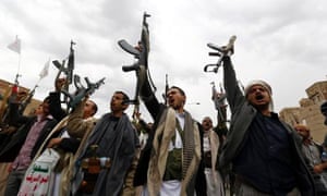Armed Houthi members hold their guns in the air in Sana’a.