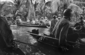 Caught in a sudden monsoon rain, part of a company of about 130 South Vietnamese soldiers moves downriver in sampans during a dawn attack on a Viet Cong camp, January 10, 1966